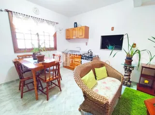 Ambiente interno de uma sala com mesa de jantar de madeira.