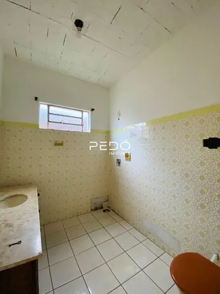 Foto de um cômodo interno com paredes amarelas e piso de cerâmica.
