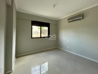 Sala de estar com piso claro e janela de grande porte.