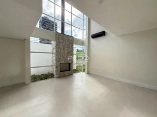 Sala de estar ampla com grande janela de vidro.