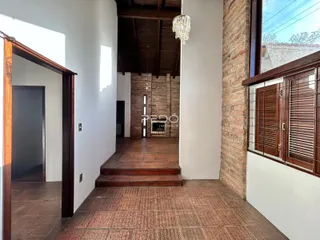 Hall de entrada com piso de cerâmica e escadaria de madeira.