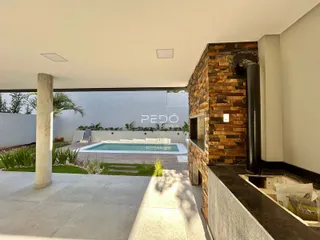 Vista externa de uma área de lazer com piscina e jardim em Lajeado.