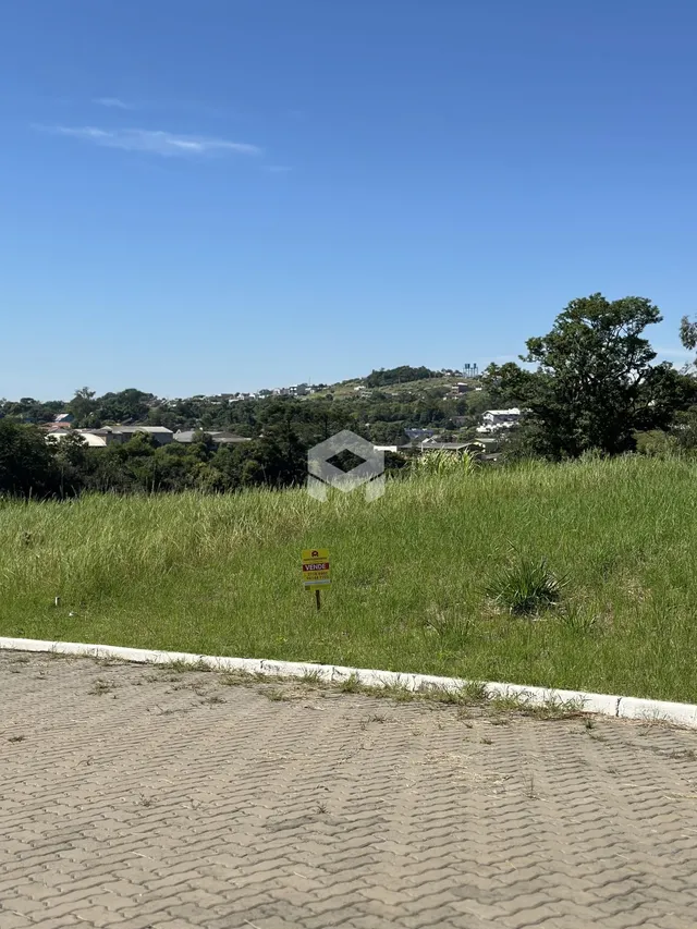 Paisagem de campo com vegetação e colinas ao fundo.