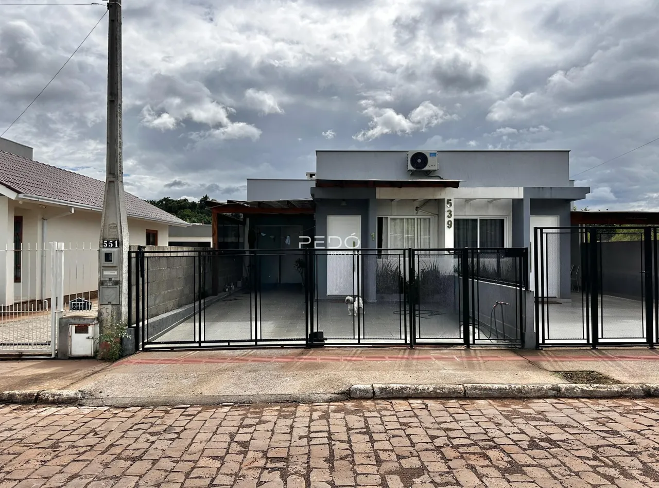 Fachada de uma residência em Lajeado, Brasil, com portão de ferro preta.