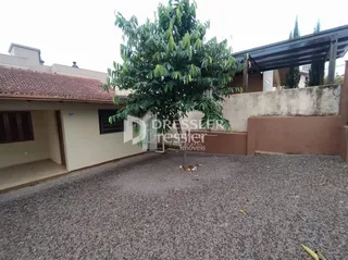 Vista da fachada de uma residência em Lajeado, Brasil com uma grande árvore no jardim.