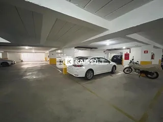 Foto de uma garagem interna com veículos estacionados.