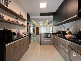 A cozinha moderna apresenta armários escuros e piso claro.