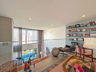 Sala de estar com vista para o exterior e janelas amplas.