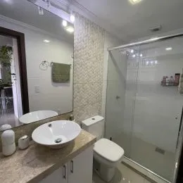 Foto de um banheiro interno com pia e vaso sanitário brancos.