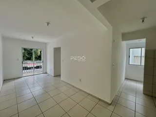 Ambiente interno de uma sala com piso de cerâmica e paredes brancas.