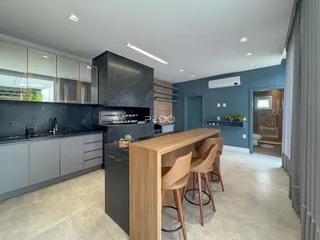 Cozinha moderna com bancadas escuras e armários de madeira.
