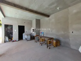 Ambiente interno com paredes de concreto aparente e teto exposto.