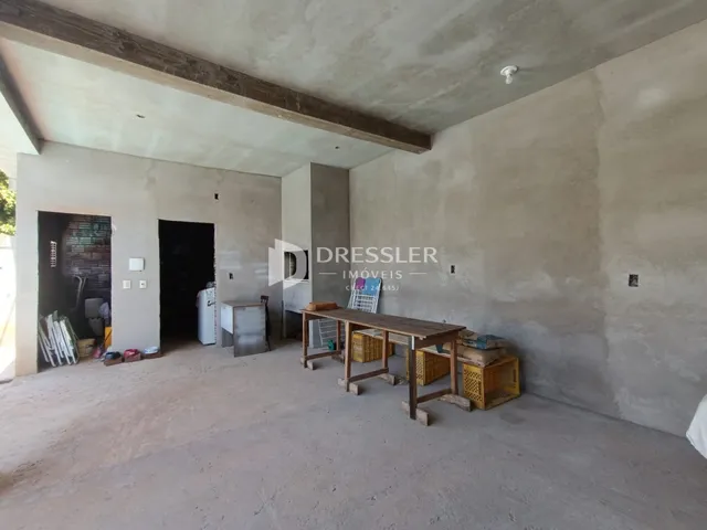 Ambiente interno com paredes de concreto aparente e teto exposto.