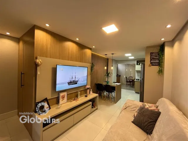 Sala de estar moderna com painel de madeira e televisão.