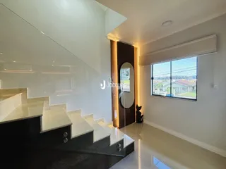 Hall com escadaria de mármore e janela com vista para o exterior.