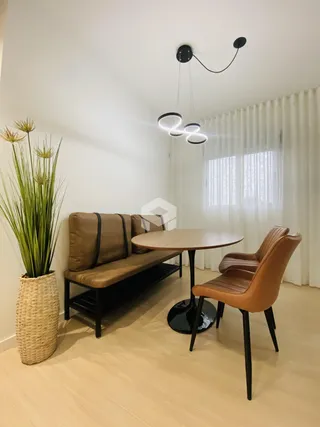 Ambiente interno com sofá e mesa de jantar em uma residência.