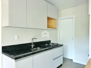 Foto de uma cozinha moderna com armários brancos e bancada escura.