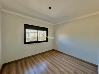 Foto de um ambiente interno com piso de madeira clara e paredes brancas.