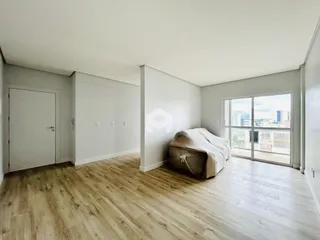 Quarto com piso de madeira clara e vista da cidade.
