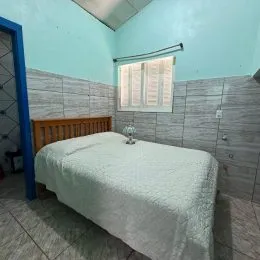 Quarto com cama de madeira e cabeceira.