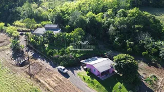 Vista aérea de uma propriedade rural cercada por vegetação densa.