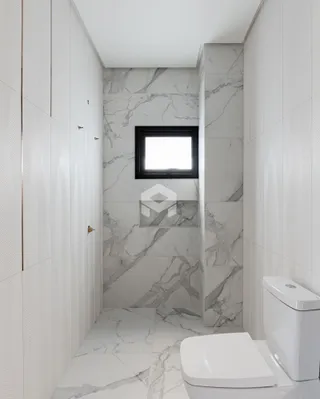 Foto de um banheiro com revestimento em mármore branco.
