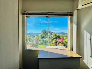 Vista da paisagem externa através de uma grande janela em uma residência.
