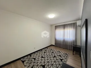Sala de estar com piso de madeira e tapete no interior da residência.