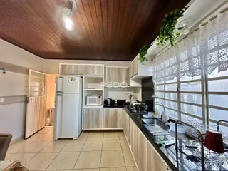 Vista da cozinha de um imóvel em Lajeado, Brasil, com armários e eletrodomésticos brancos.