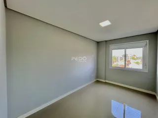 Interior de uma sala com paredes cinzas e piso claro.
