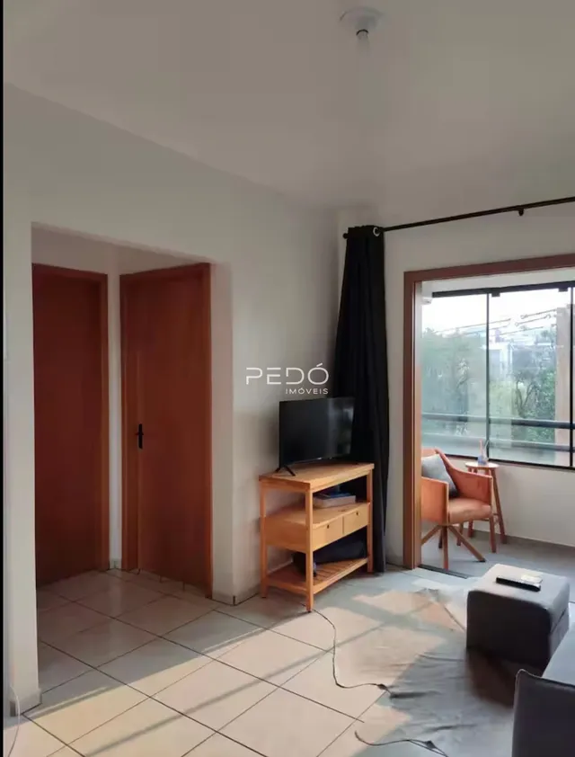 Sala de estar com portas de madeira e piso de cerâmica clara.