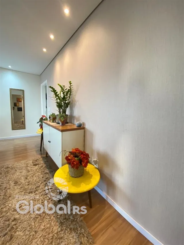 Interior de uma sala com piso de madeira e tapete.