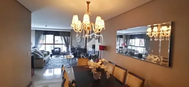Sala de estar com luminária de cristal e espelho grande.