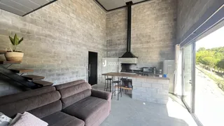 Sala de estar com paredes de tijolo aparente e lareira em um imóvel no Brasil.