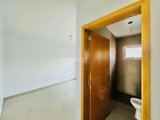 Interior de um corredor com porta de madeira em um imóvel no Brasil.