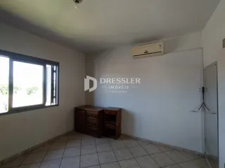 Ambiente interno de uma sala com piso de cerâmica e móveis de madeira.