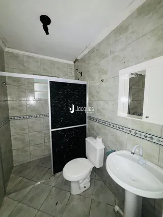 Foto interna de um banheiro com revestimento cerâmico e azulejos.