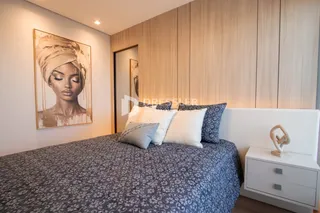 Foto de um quarto moderno com cabeceira branca e painéis de madeira.