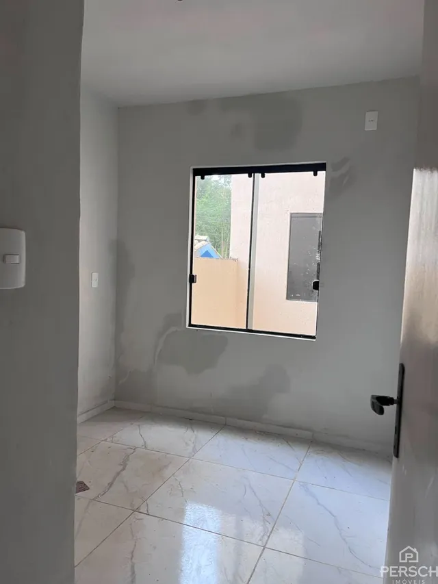 Foto de um cômodo interno com piso de cerâmica e uma porta grande.