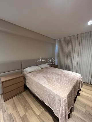 Quarto com cama e móveis de madeira no interior da propriedade.