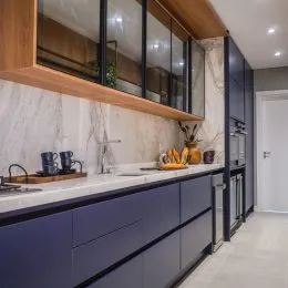 Foto de uma cozinha moderna com armários escuros e bancadas claras.