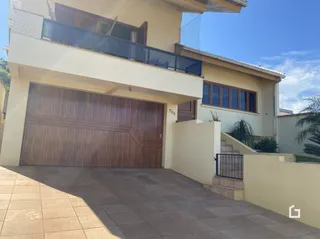 A fachada de uma residência em Lajeado, Brasil, com porta de garagem de madeira.