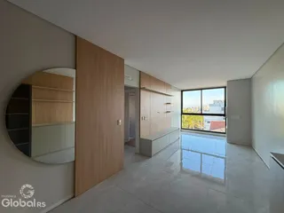 Sala de estar com grande janela e piso claro em imóvel em Lajeado.