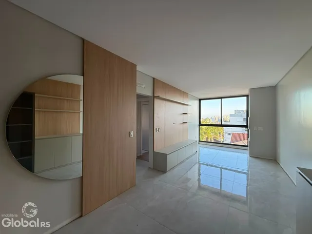 Sala de estar com grande janela e piso claro em imóvel em Lajeado.