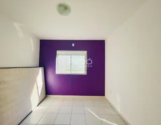 Uma sala com parede roxa e piso claro.
