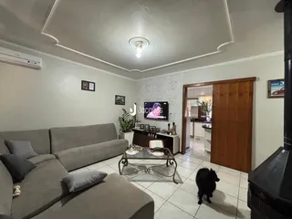 Sala de estar com sofá e piso de cerâmica clara.
