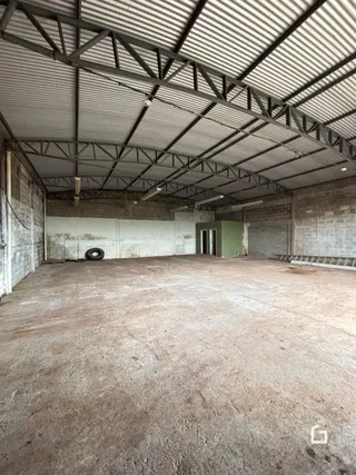 Espaço interno amplo com estrutura de telhado metálico exposta.