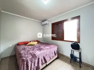 Quarto com cama grande e janela de madeira em um imóvel em Lajeado.
