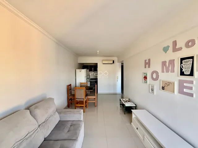 Sala de estar com sofá e decoração de parede em um imóvel.