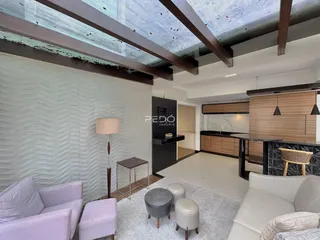 Sala de estar com paredes texturizadas e vigas expostas.